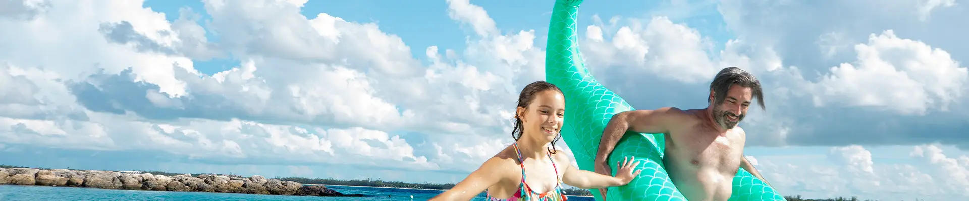A Father and Daughter playing in the ocean on a Carnival holiday