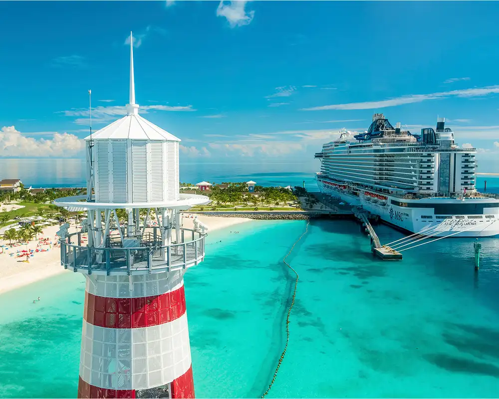 The lighthouse of Ocean Cay Infront of the dock with an MSC Ship