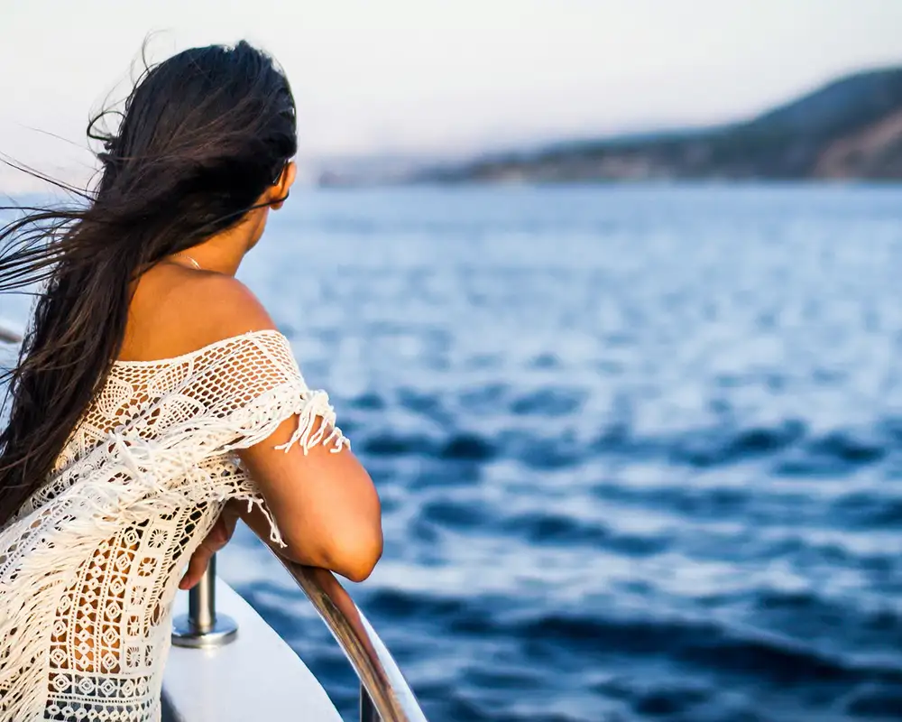 A Woman leaning on a railing looking out over the ocean