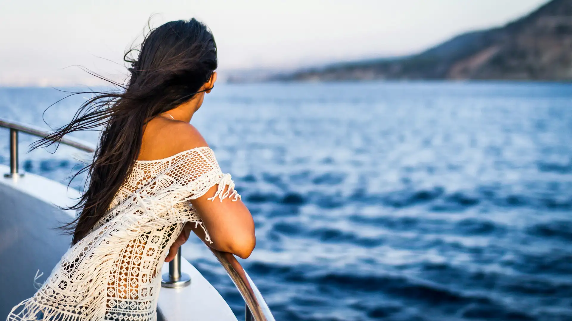 A Woman leaning on a railing looking out over the ocean