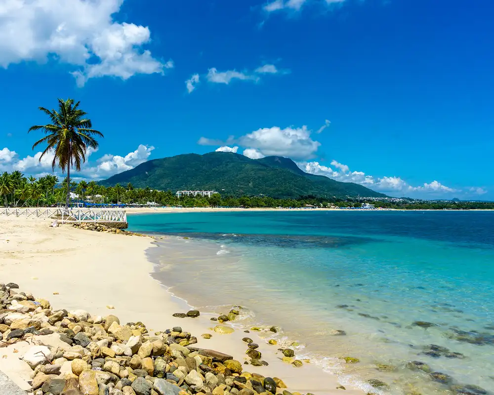 A Caribbean beach with a mountain in the distance