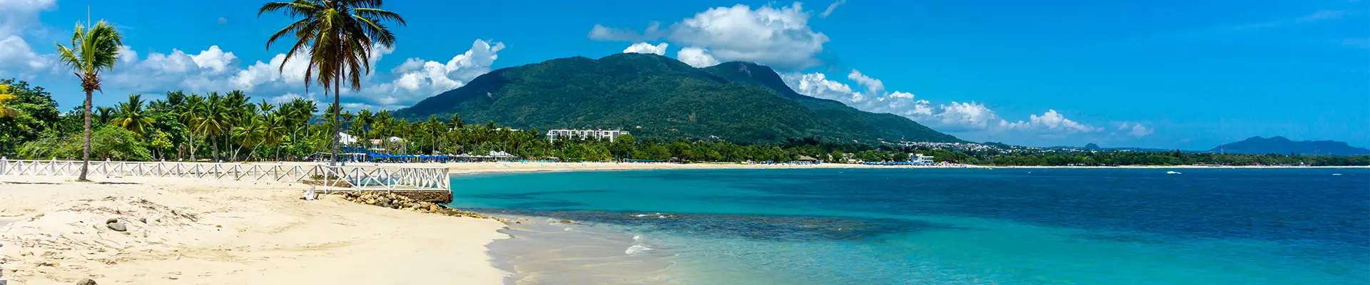 A Caribbean beach with a mountain in the distance