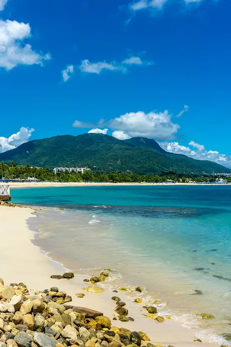 A Caribbean beach with a mountain in the distance