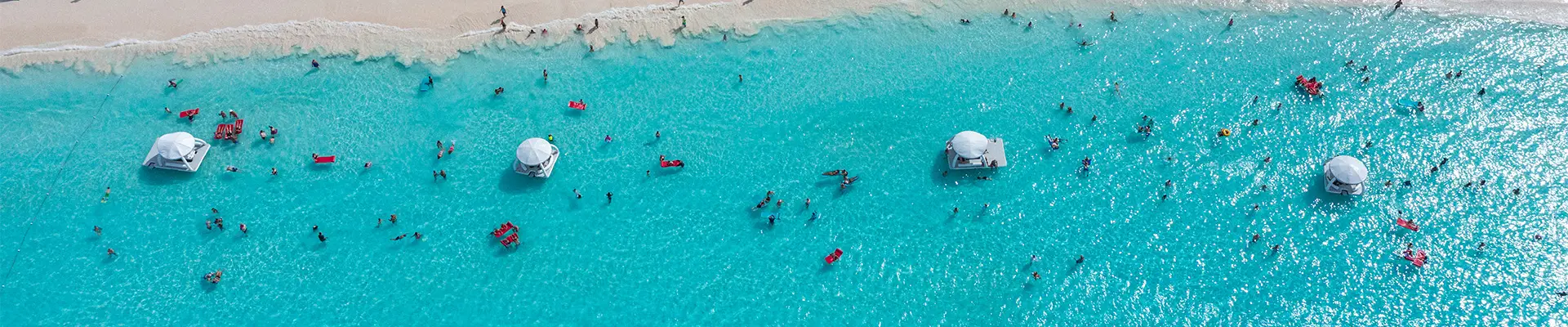 An Aerial image of the beach of Half Moon Cay filled with people