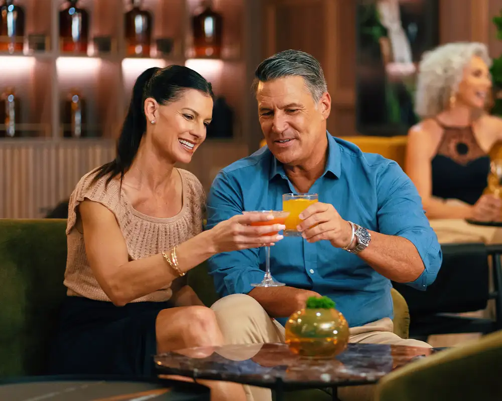 A Couple enjoying drinks in a bar aboard an Azamara Ship