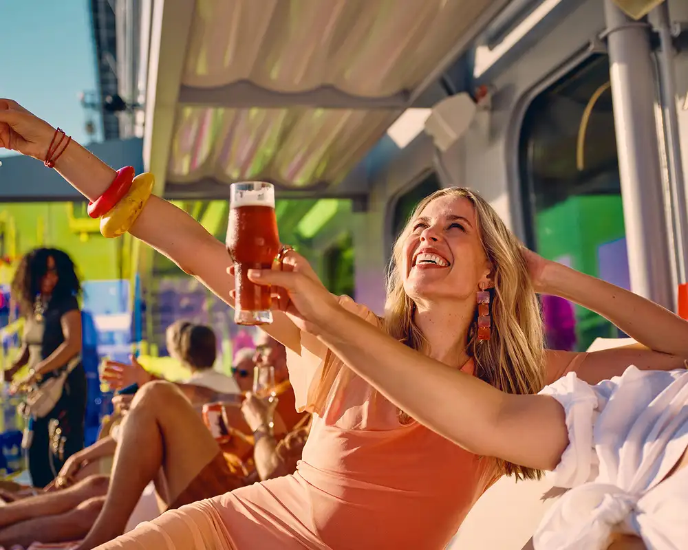 Women holding drinks onboard a Virgin Voyages Sailing
