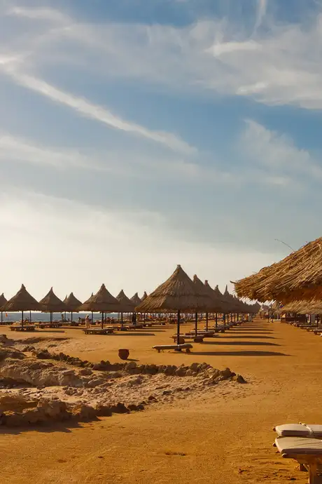 Summer beach under morning sun in Egypt Sharm el-sheikh Morning - plank beds and umrellas