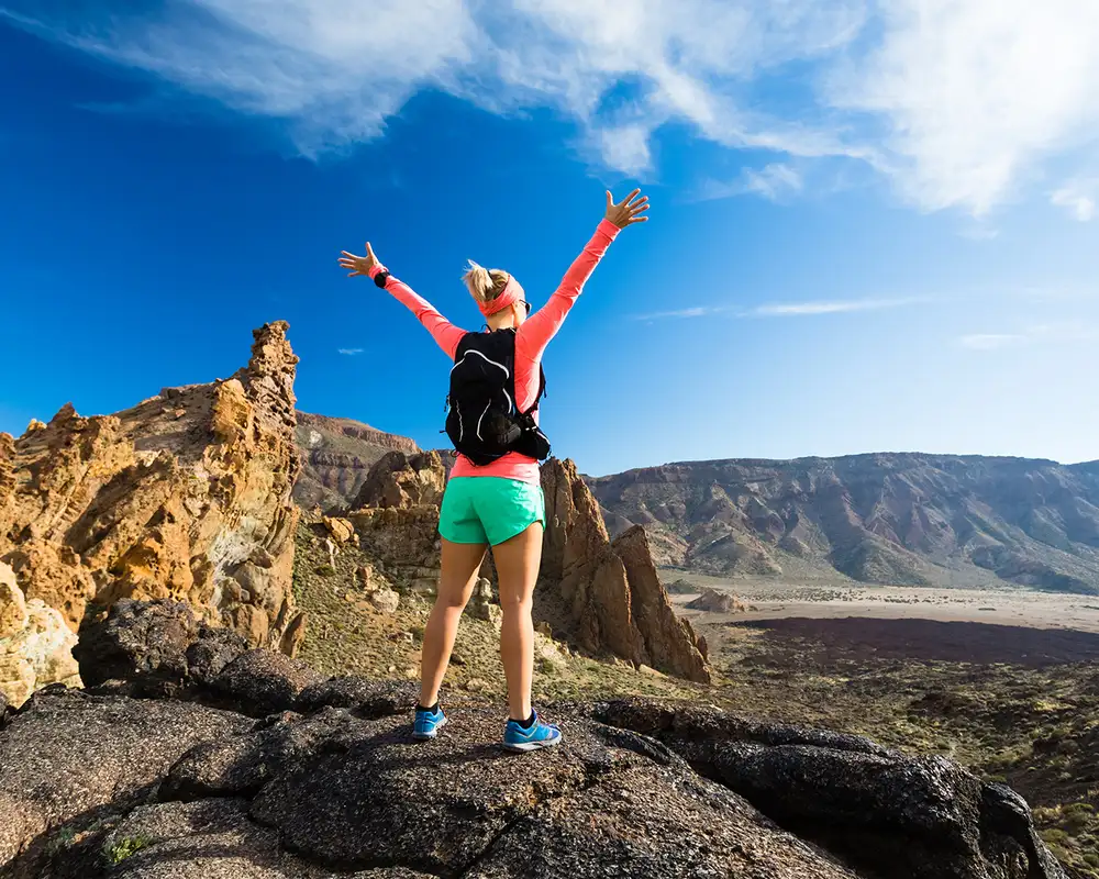 A woman celebrating at the top of a hill in the Canary Islands