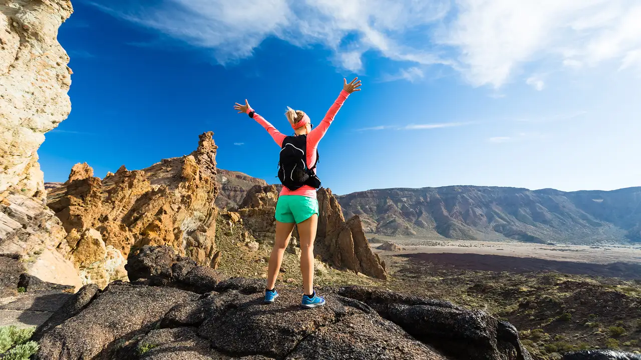 A woman celebrating at the top of a hill in the Canary Islands