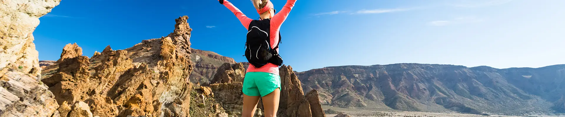 A woman celebrating at the top of a hill in the Canary Islands