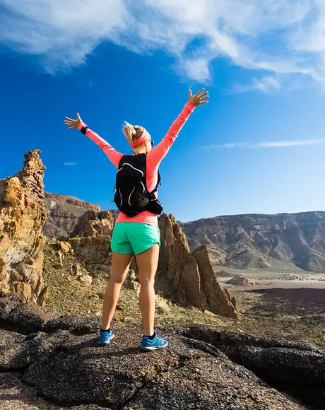A woman celebrating at the top of a hill in the Canary Islands
