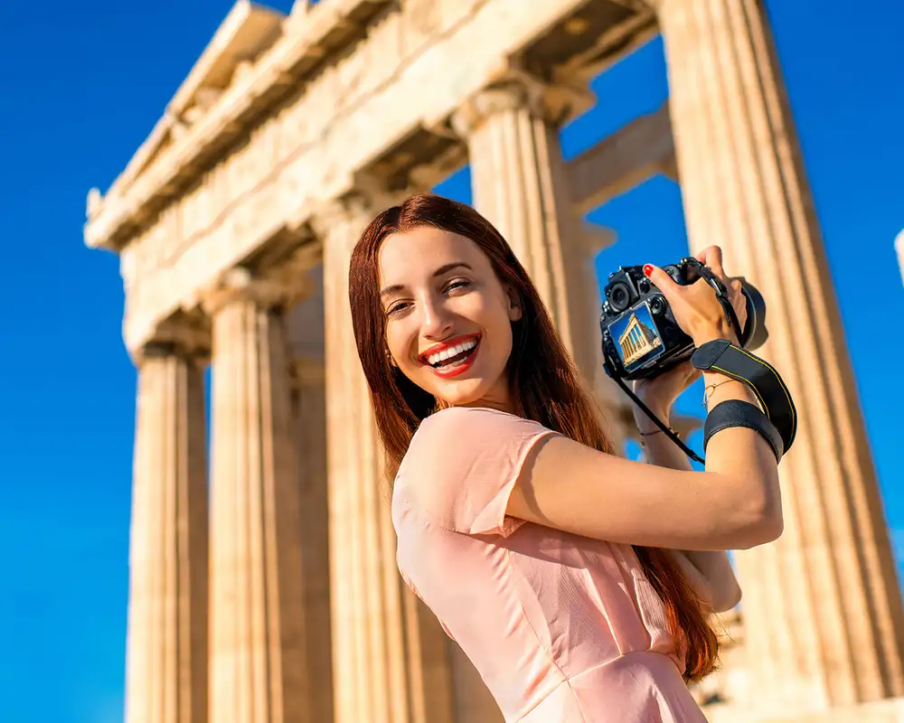 A Woman taking a picture of the Acropolis in Athens, Greece