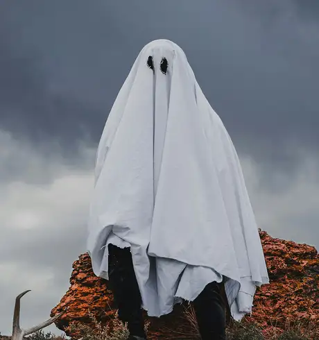 A man wearing a ghost costume