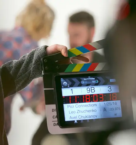 A person using a clapperboard to start filming a film