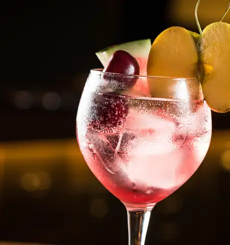 A Cocktail server with cherries, watermelon and a peach
