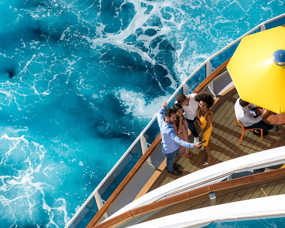 A Group of friends taking a selfie standing by the railings on the deck of a Costa Cruise Ship