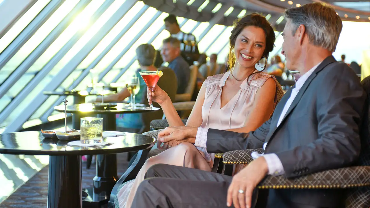 A couple enjoying drinks in a bar aboard a Oceania Cruise Ship