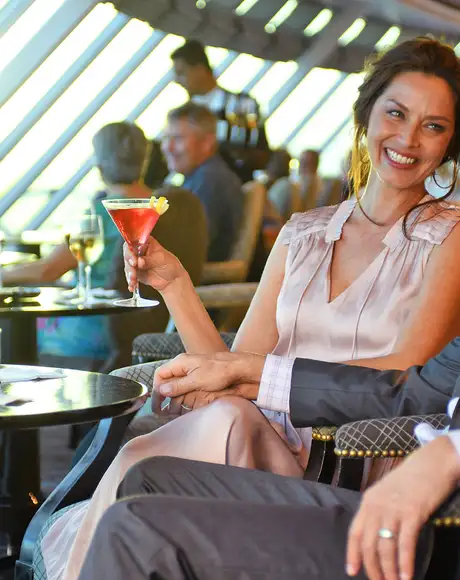 A couple enjoying drinks in a bar aboard a Oceania Cruise Ship
