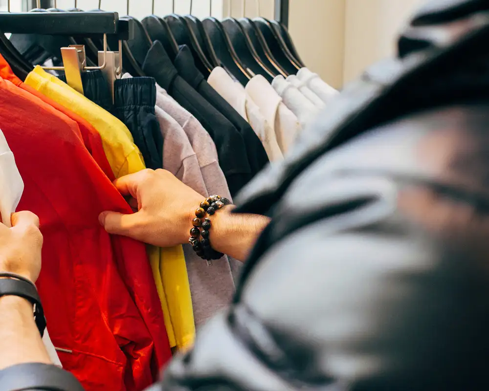 Someone browsing through clothes in a shop