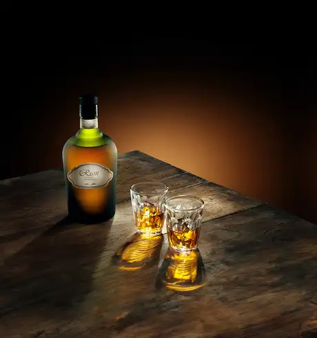 A bottle of rum with some glasses