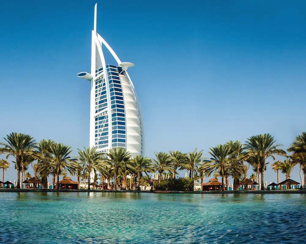 A view of water surrounded with palm trees and the Burj Al Arab in Dubai