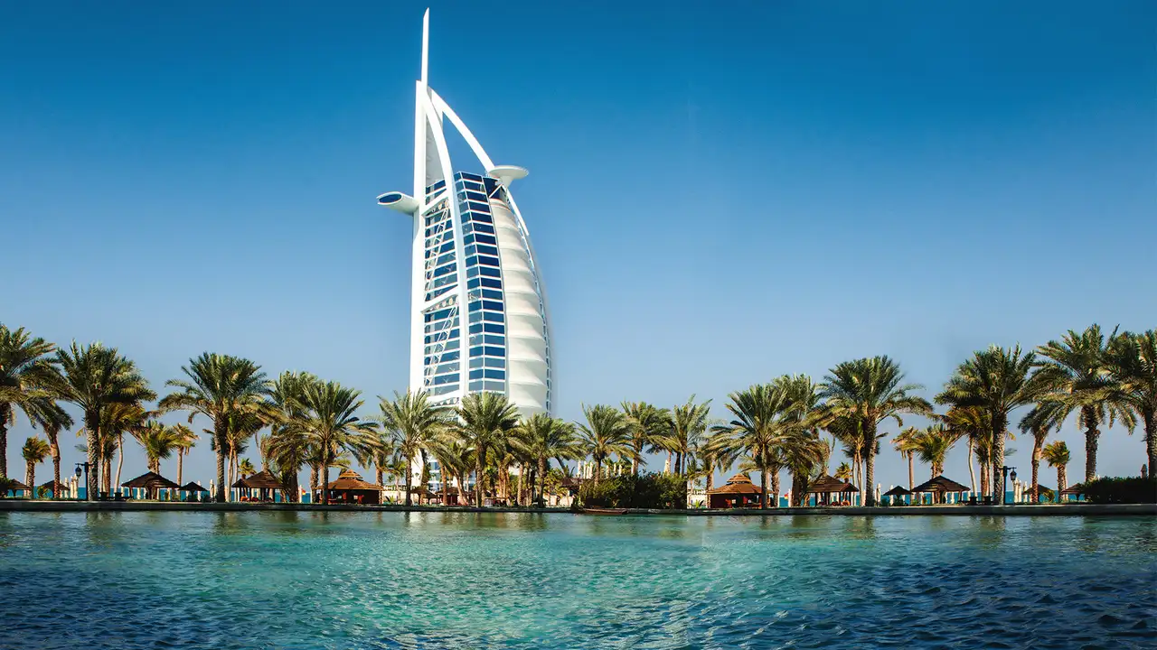 A view of water surrounded with palm trees and the Burj Al Arab in Dubai