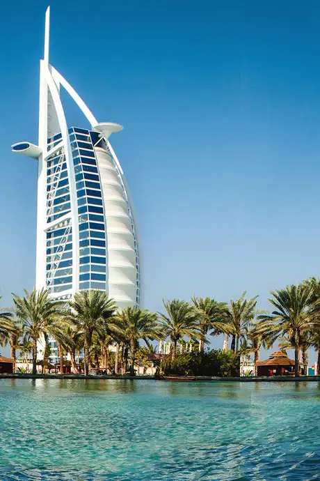 A view of water surrounded with palm trees and the Burj Al Arab in Dubai