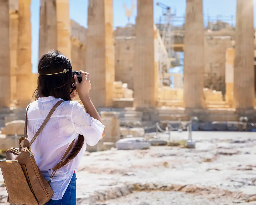 A Woman Taking a picture of the Acropolis in Athens