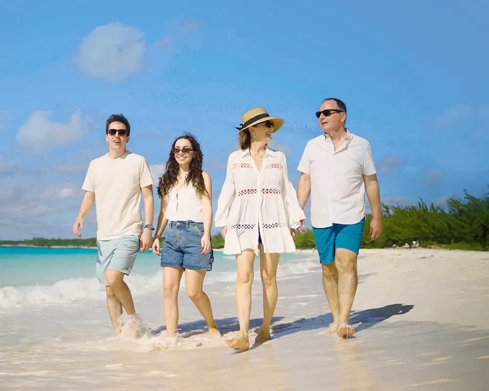A family walking on a beach on Half Moon Cay