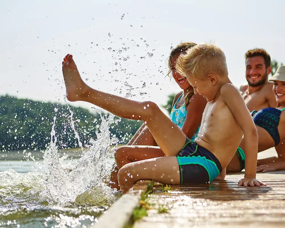 A family playing at the side of a body of water