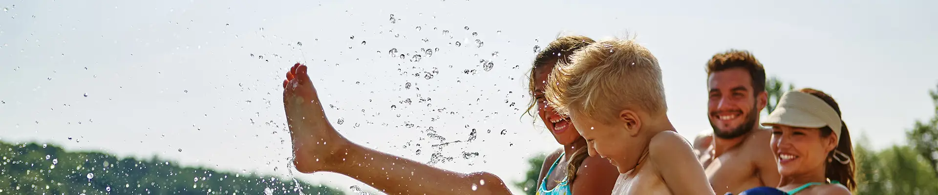 A family playing at the side of a body of water