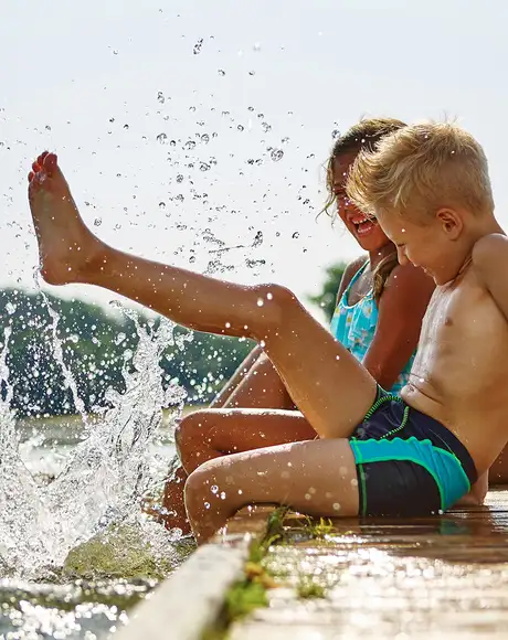 A family playing at the side of a body of water