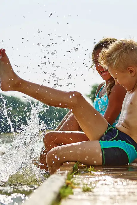 A family playing at the side of a body of water