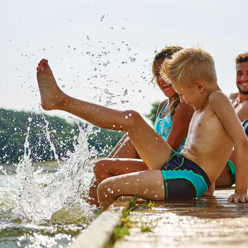 A family playing at the side of a body of water