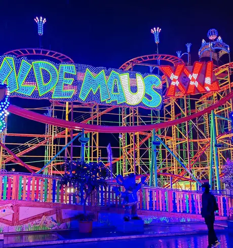 A Rollercoaster ride, lit up at night during a Hamburg DOM Fun Fair