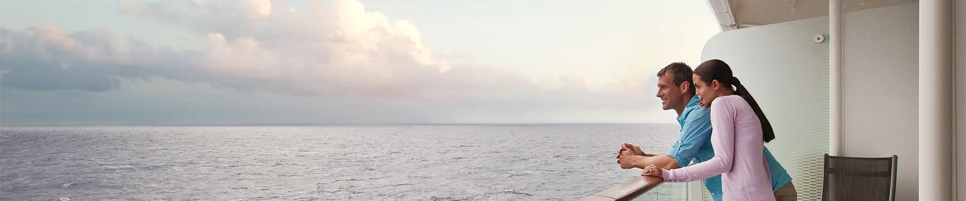 A couple leaning on a railing on a Celebrity Ship