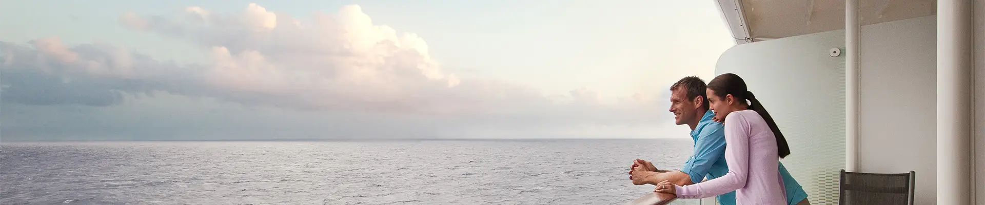 A couple leaning on a railing on a Celebrity Ship