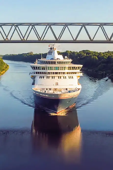 A Fred Olsen Ship cruising down a river