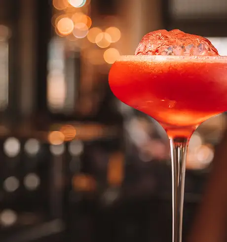 A red coloured Cocktail served with Ice