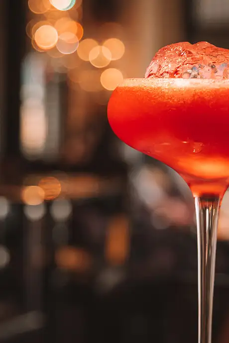 A red coloured Cocktail served with Ice