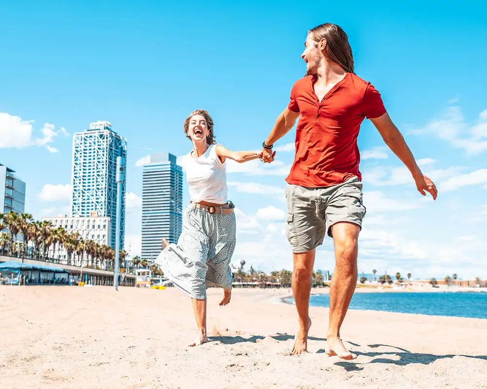 A Couple running down a beach in Barcelona