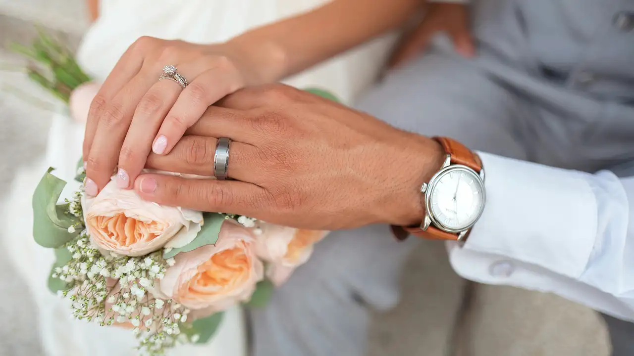 A couple holding hands on their wedding day