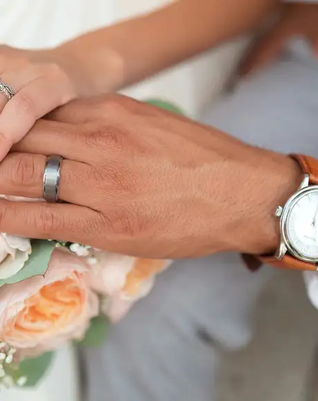 A couple holding hands on their wedding day