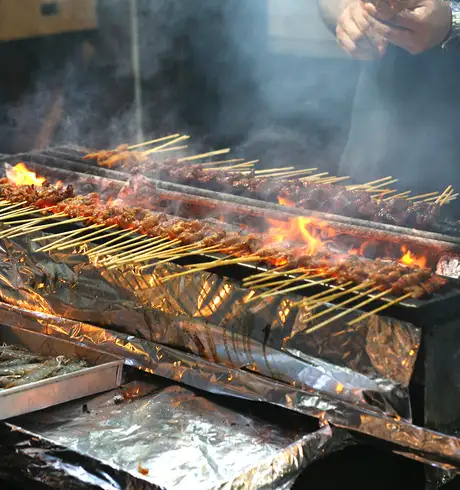 A grill cooking skewers