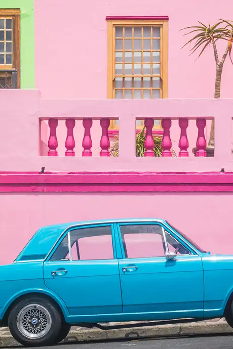 A Blue Car parked outside of the Colourful buildings of Bo-Kaap, in Cape Town