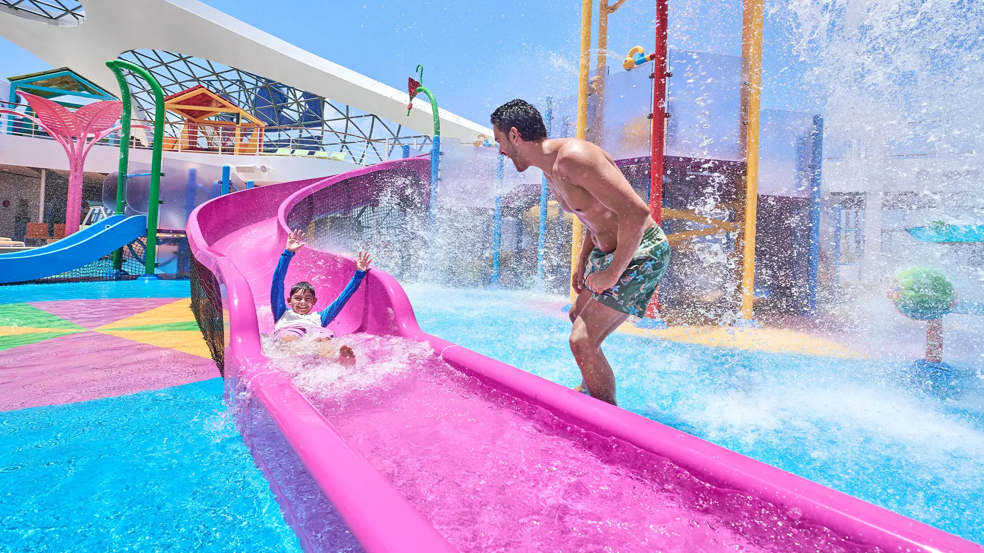 A Father watching his Son come down a water slide onboard a Royal Caribbean Ship
