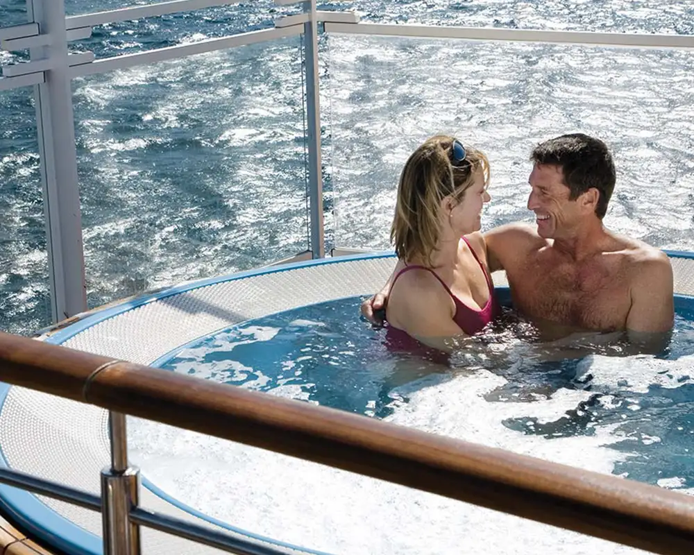 A couple sitting in a hot tub together aboard a Silversea Ship