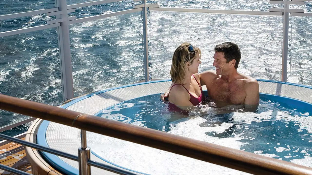 A couple sitting in a hot tub together aboard a Silversea Ship