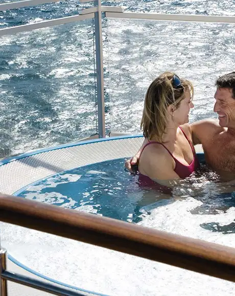 A couple sitting in a hot tub together aboard a Silversea Ship
