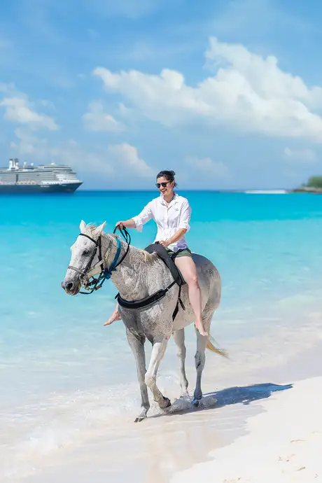 A woman riding a hose down the coast of Half Moon Cay